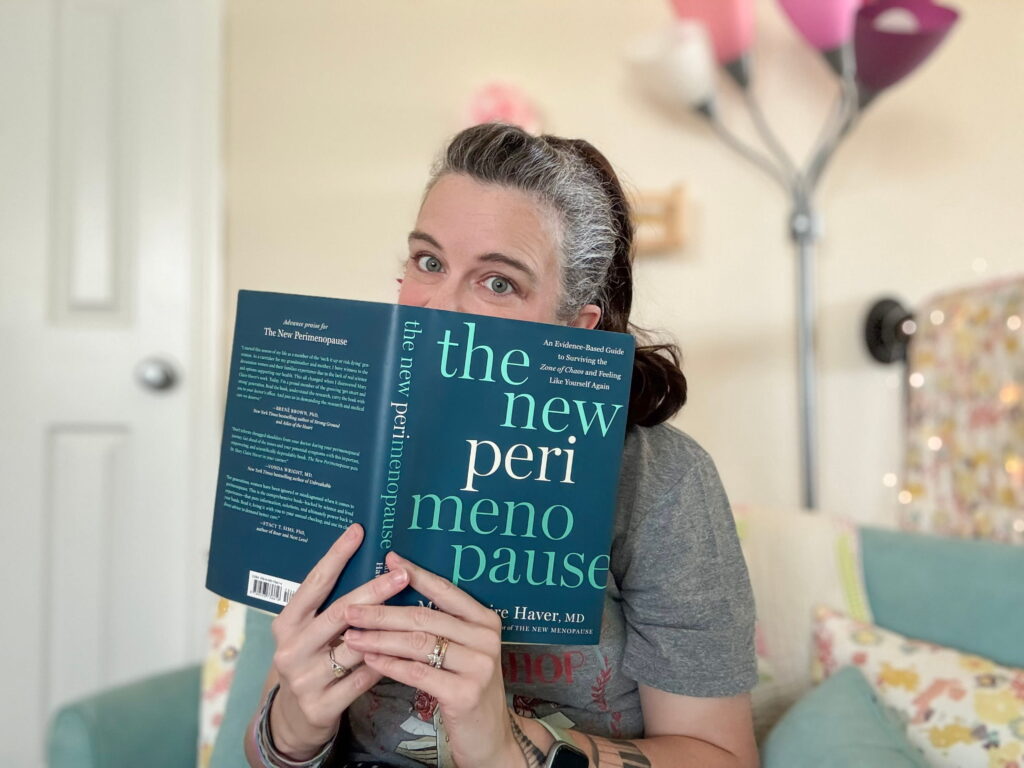 woman with a ponytail peeking from behind a summer book club- book